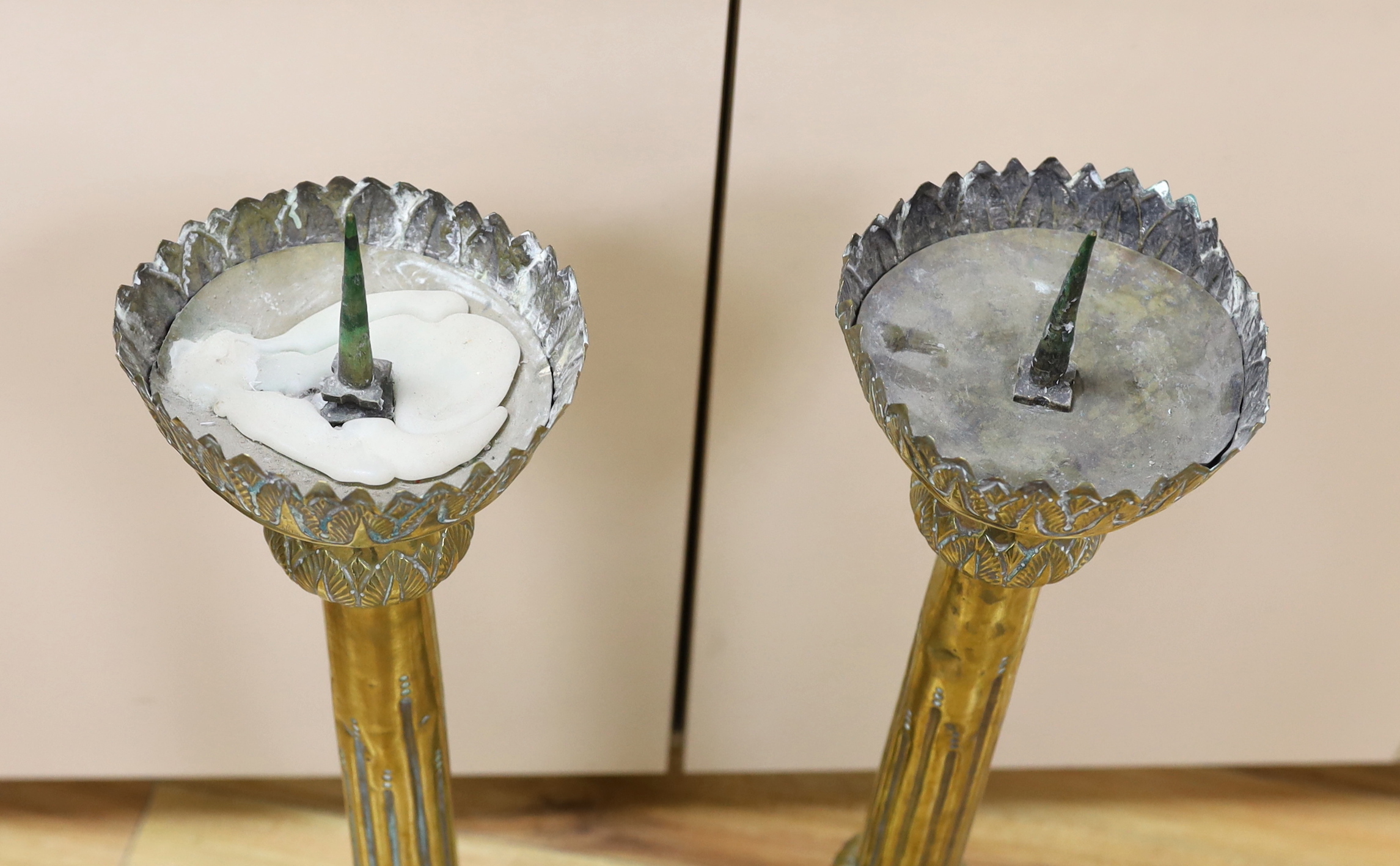 A pair of tall 19th century repoussé brass pricket altar sticks, 76cm high